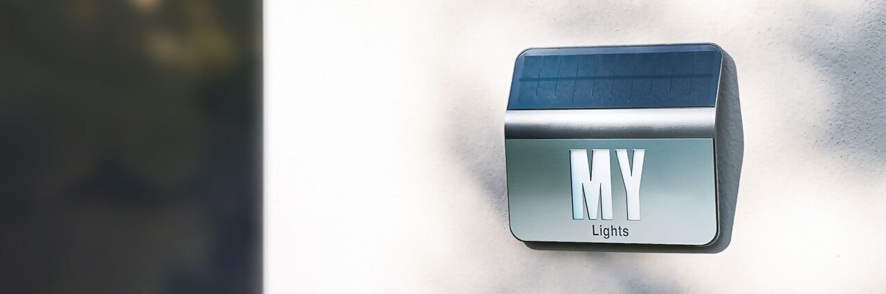 Solarbetriebene Hausnummernleuchte mit individueller Beschriftung „MY Lights“ an einer Hauswand.