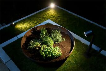 Kräutergarten bei Nacht, beleuchtet durch mehrere Steinel Spots für gezielte Lichtakzente.