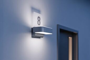 Moderne, beleuchtete Hausnummer „8“ auf einer Steinel-Außenleuchte, montiert an einer Hauswand.