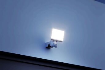 Heller LED-Außenstrahler mit Bewegungsmelder, montiert an einer Hauswand, sorgt für sichere und energieeffiziente Beleuchtung.